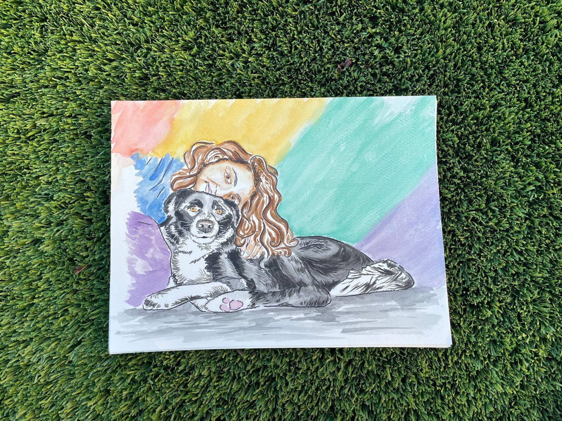 Painting of a person and black dog on colorful background, lying on grass.